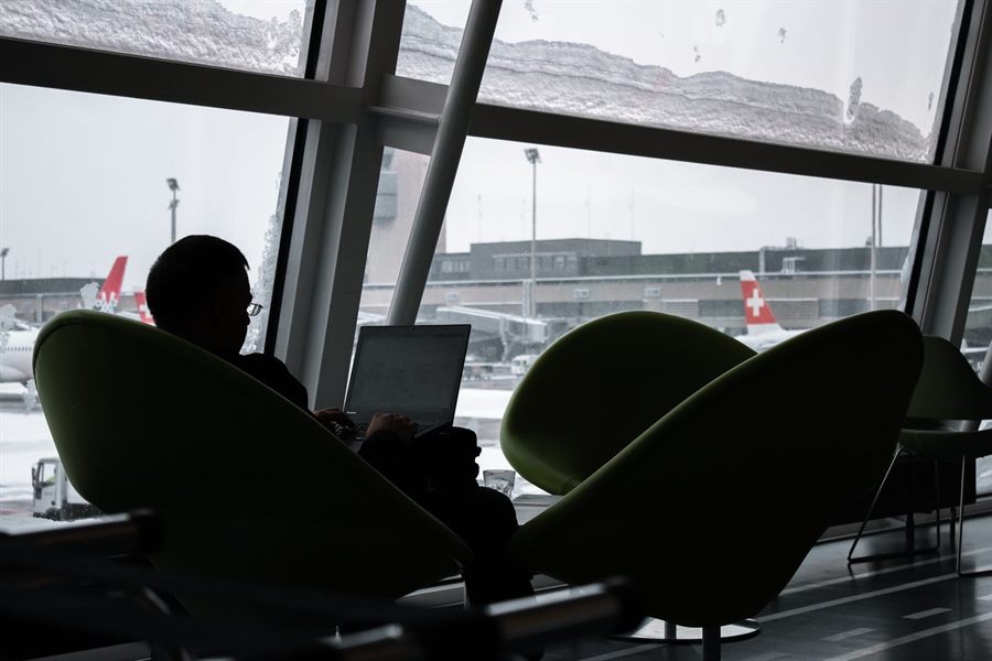 Traveler using a laptop at an airport
